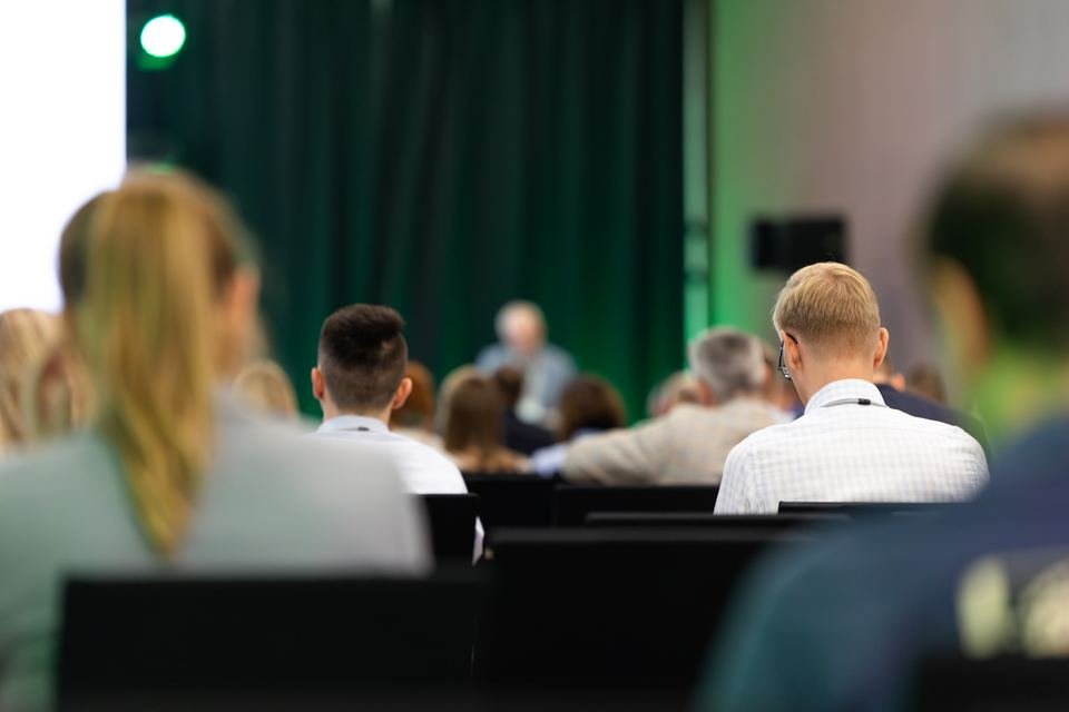 Asistentes siguiendo una exposición en una sala de conferencias