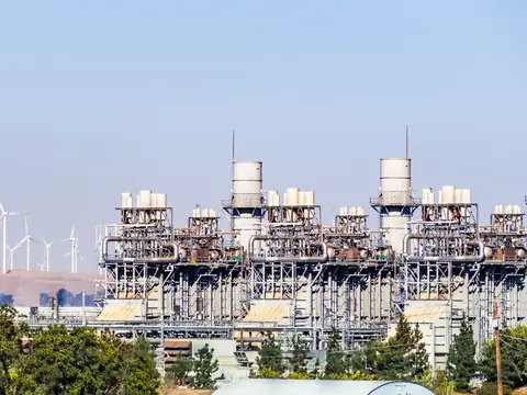 Aerogeneradores y líneas eléctricas contra un cielo despejado