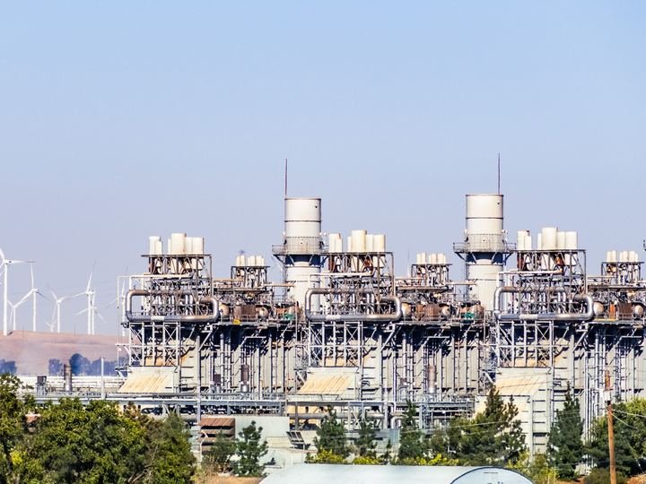 Aerogeneradores y líneas eléctricas contra un cielo despejado
