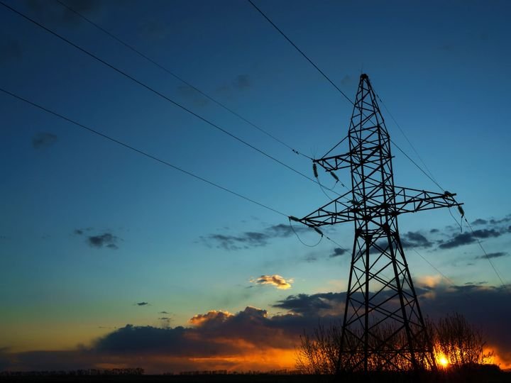Líneas de transmisión eléctrica contra un cielo de atardecer