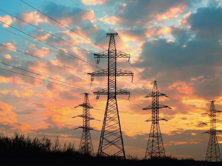 Silueta de una torre de alta tensión al anochecer