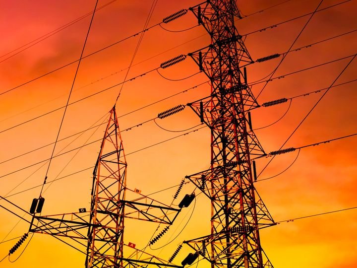 Estación de postes eléctricos de alta tensión al atardecer